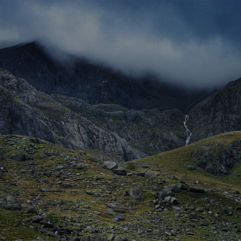 Mountainous landscape with rocky terrain and a waterfall.