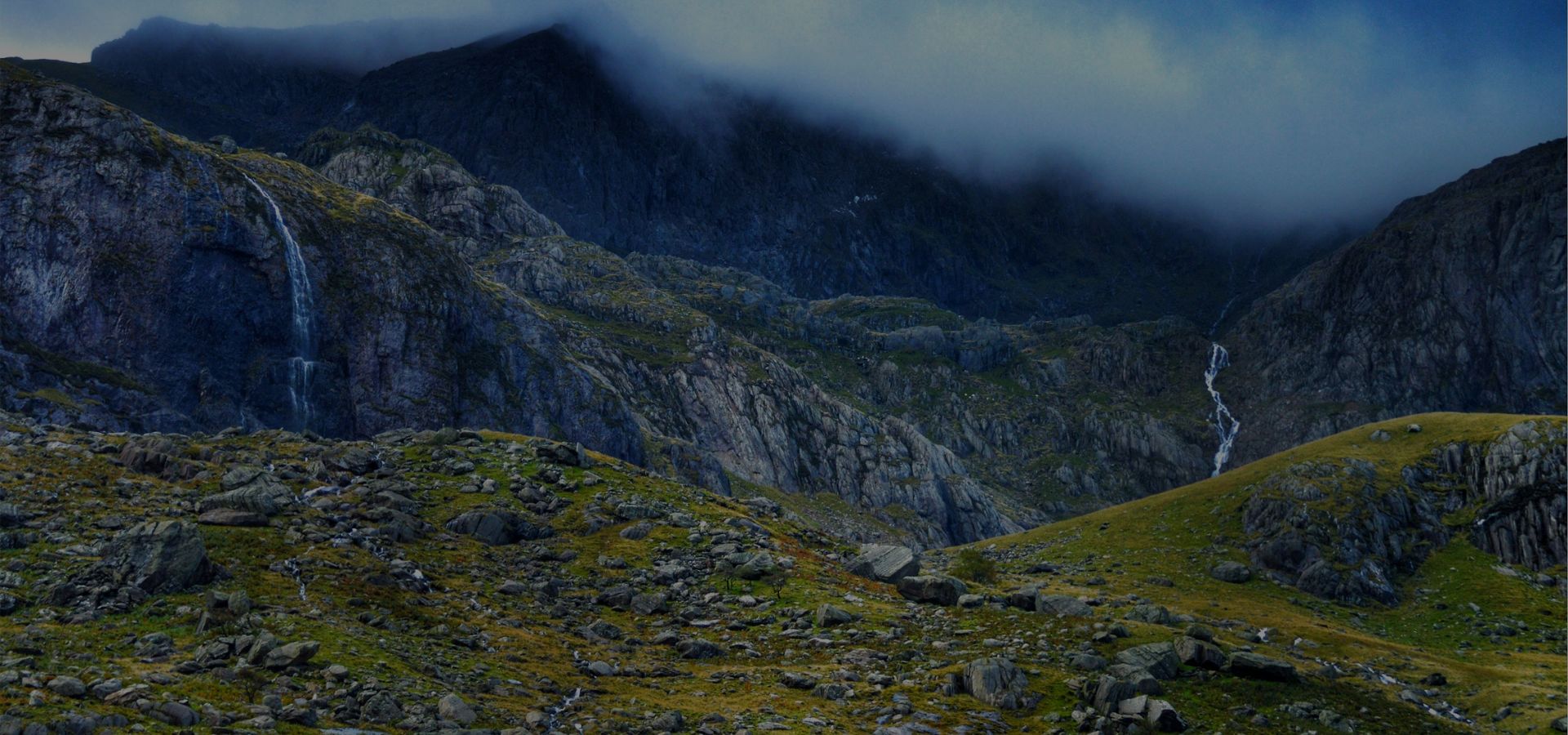 Mountainous landscape with rocky terrain and a waterfall.